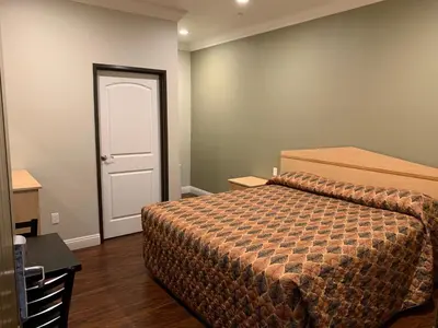 a bedroom with a bed and a white door at El Rey Inn - LAX in Gardena