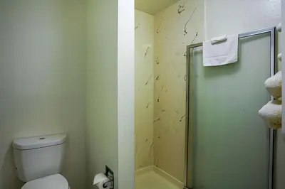 a bathroom with a toilet and a glass shower at Motel 6-Ventura, CA - Downtown in Ventura