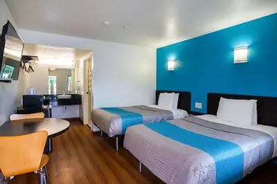 a hotel room with two beds and a table at Motel 6-Ventura, CA - Downtown in Ventura