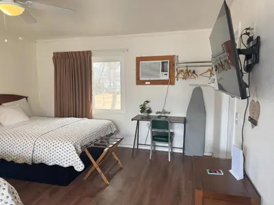 a bedroom with a bed and a desk and a table at Lakeshore Lodge in Wofford Heights