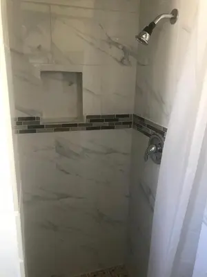 a bathroom with a shower with white marble at All 8 Motel in Long Beach