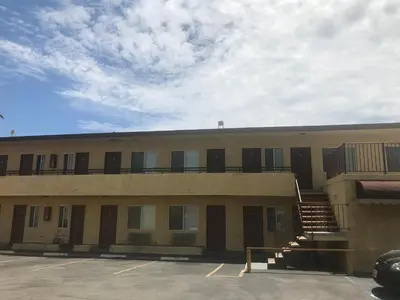 a building with a parking lot in front of it at All 8 Motel in Long Beach
