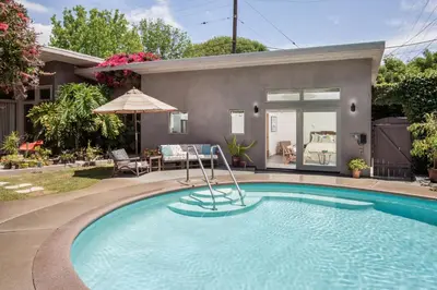 a swimming pool in front of a house at Mid-Mod Retro Private Studio & Pool in Long Beach