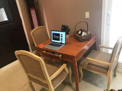 a wooden table with a laptop computer on it at paradise luxury experience in Woodland Hills