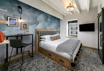 a bedroom with a bed and a desk and a television at The Wayfarer Downtown LA, Tapestry Collection by Hilton in Los Angeles