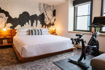 a bedroom with a bed and a treadmill at The Wayfarer Downtown LA, Tapestry Collection by Hilton in Los Angeles