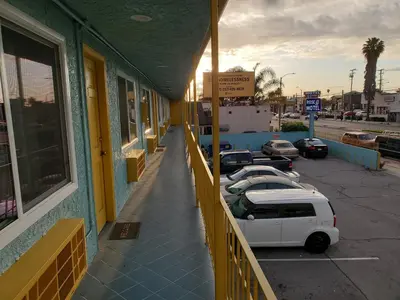 a white van parked in a parking lot outside a building at Rose motel in Compton