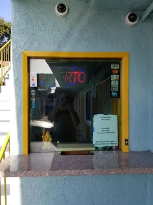 a reflection of a person taking a picture in a mirror at Rose motel in Compton