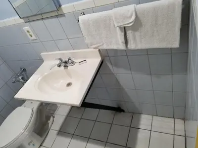 a bathroom with a sink and a toilet and towels at Rose motel in Compton