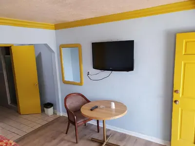 a room with a table and a tv on a wall at Rose motel in Compton