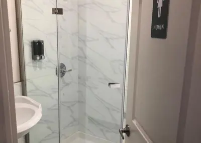 a bathroom with a glass shower with a sink at 8th and Ardmore in Los Angeles