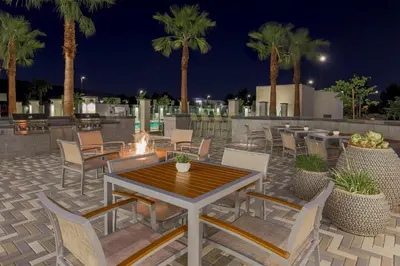 a patio with tables and chairs and palm trees at night at Element Ontario Rancho Cucamonga in Ontario