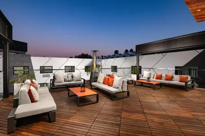 a patio with couches and tables on a roof at The Moment Hotel in Los Angeles