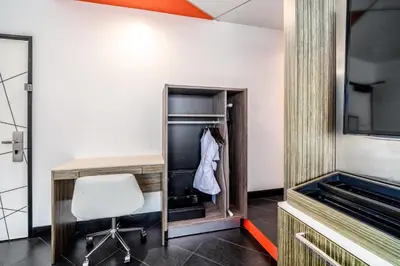 a room with a desk and a chair and a tv at The Moment Hotel in Los Angeles