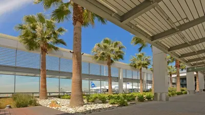 a group of palm trees in front of an airport at Motel 6 San Pedro, CA Port of Los Angeles in San Pedro