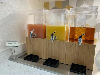 a drink dispenser with three bottles of orange juice at Hyatt Place Bakersfield in Bakersfield