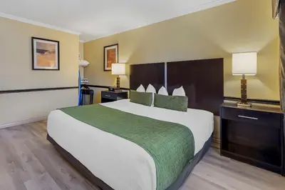 a hotel room with a large bed and two lamps at Best Western Canoga Park Motor Inn in Canoga Park
