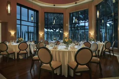 a banquet room with tables and chairs and windows at L'Ermitage Beverly Hills in Los Angeles
