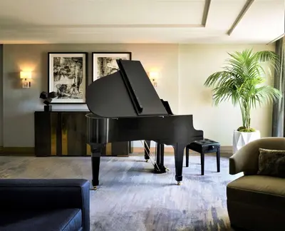 a black piano in a living room at L'Ermitage Beverly Hills in Los Angeles