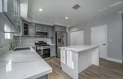 a large kitchen with white counter tops and appliances at Green HomeStay address changed in Los Angeles