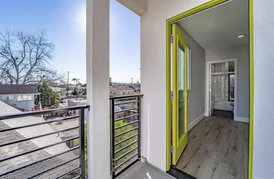 a balcony with a yellow door on a building at Green HomeStay address changed in Los Angeles