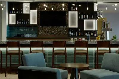 a bar with chairs and a counter with wine bottles at Courtyard by Marriott Thousand Oaks Agoura Hills in Agoura Hills