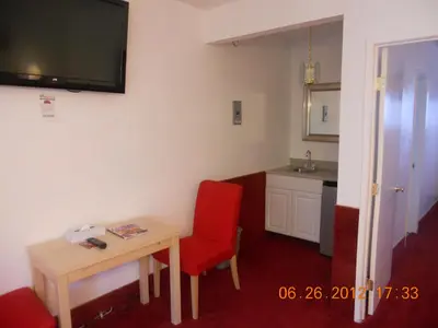 a small room with a table and a red chair at Tradewinds Airport Hotel in Inglewood