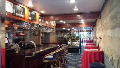 a bar with a row of tables and chairs at Tradewinds Airport Hotel in Inglewood