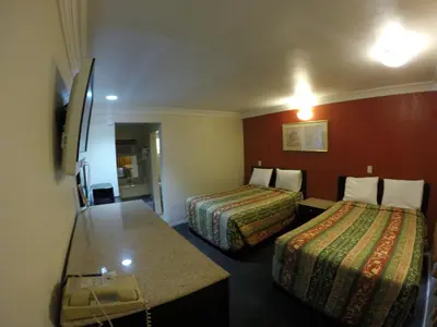 a hotel room with two beds and a television at Calico Motel in Anaheim