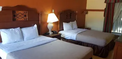 a hotel room with two beds and a lamp at Lotus by Hotel Inn in Ontario