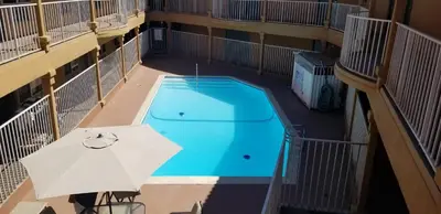 an umbrella and a swimming pool in a building at Lotus by Hotel Inn in Ontario