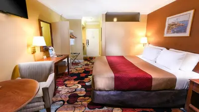 a hotel room with a bed and a desk at Vagabond Inn Long Beach in Long Beach