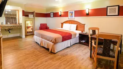 a hotel room with a large bed and a desk at Aqua Venture Inn in Long Beach