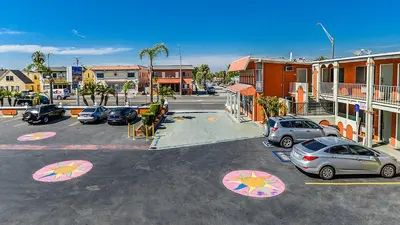 a parking lot with cars parked in front of buildings at Aqua Venture Inn in Long Beach