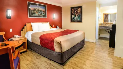 a hotel room with a large bed and a table at Aqua Venture Inn in Long Beach