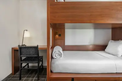 a bedroom with a bunk bed and a chair at FOUND Hotels, Santa Monica, Series by Marriott in Los Angeles