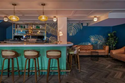 a bar with stools and a couch in a room at FOUND Hotels, Santa Monica, Series by Marriott in Los Angeles