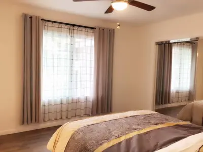 a bedroom with two windows with curtains and a bed at Fully remodeled Beautiful house in West Covina in West Covina