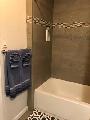 a bathroom with a tub and a shower with blue towels at Fully remodeled Beautiful house in West Covina in West Covina