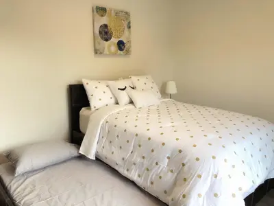 a bedroom with a large bed with white sheets and pillows at Fully remodeled Beautiful house in West Covina in West Covina