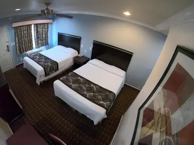 a hotel room with two beds and a balcony at Hollywood Guest Inn in Los Angeles