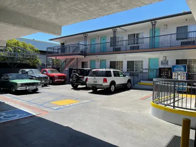 a parking lot with cars parked in front of a building at Hollywood Guest Inn in Los Angeles