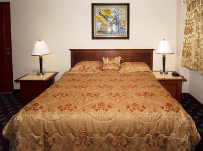 a bed in a hotel room with two lamps on tables at Metro Plaza Hotel in Los Angeles