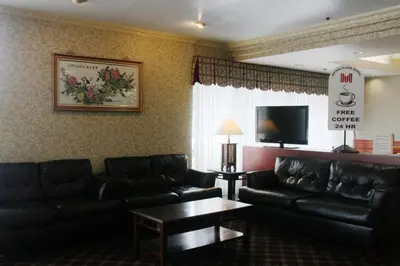 a living room with black leather furniture and a flat screen tv at Metro Plaza Hotel in Los Angeles