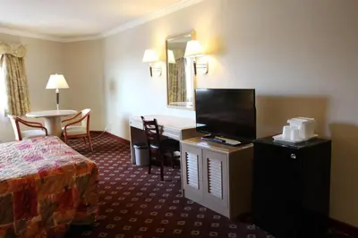 a hotel room with a bed and a desk and a table at Metro Plaza Hotel in Los Angeles
