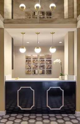 a lobby with a black counter and lights at Carlyle Inn in Los Angeles