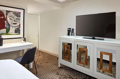 a hotel room with a flat screen tv on a dresser at Carlyle Inn in Los Angeles