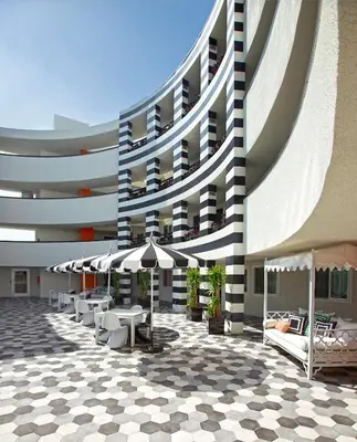 a building with tables and chairs and umbrellas at Carlyle Inn in Los Angeles