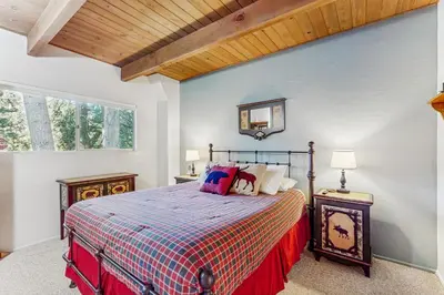 a bedroom with a bed with a red blanket at The Treehouse in Lake Arrowhead