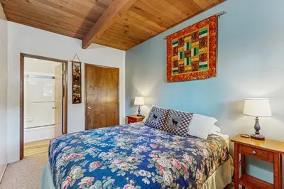 a bedroom with a bed and a painting on the wall at The Treehouse in Lake Arrowhead
